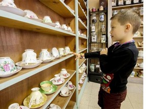 Six-year-old Oscar Geraud checks out the large selection of tea cups for customers at the Mademoiselle Clifford Tea Room on Cameron St.