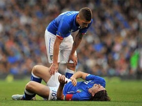 Italy’s midfielder Riccardo Montolivo lies injured as Italy’s midfielder Marco Verratti stands over him during the international friendly football match between Italy and the Republic of Ireland at Craven Cottage in London on Saturday.