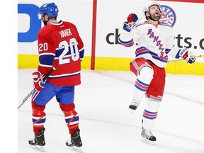 Martin St. Louis of the New York Rangers celebrates his goal in the first period of the Eastern Conference final of the NHL playoffs in Montreal, on Saturday, May 17, 2014. On the left is Thomas Vanek of the Montreal Canadiens.