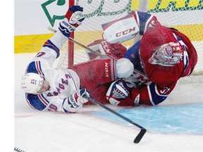Montreal Canadiens goalie Carey Price is hit by New York Rangers left wing Chris Kreider, left, as Kreider crashes in to price skate blade first during game 1 round 3 NHL playoff action at the Bell Centre in Montreal on Saturday May 17, 2014.