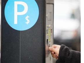 A motorist feeds a parking meter in downtown Montreal.