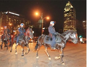 Mounted police ride down Rene Levesque Blvd. after Habs Stanley Cup series victory over the Bruins in Boston, in Montreal Wednesday May 14, 2014.