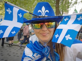 Cathy Merray shows her colours proudly during the Marche des Patriotes in Montreal on Monday. Between 150 and 200 people gathered at Dominion Square for speeches, folk songs and a march to Camille Laurin Park.