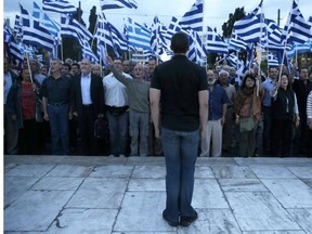 Ilias Kasidiaris of the extreme-right Golden Dawn party stands at attention as supporters sing the Greek national anthem during a rally outside Parliament in central Athens on Thursday, May 29, 2014. The party came third in European Parliament elections held in Greece on Sunday, May 25.