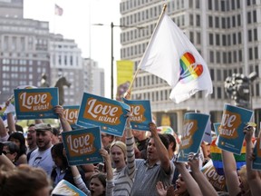 People hold up signs and cheer during a rally at City Hall, Tuesday, May 20, 2014, in Philadelphia. Pennsylvania's ban on gay marriage was overturned by a federal judge Tuesday. (AP Photo/Matt Slocum)