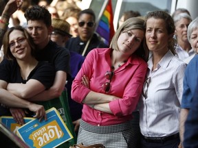 From right, Viola Vetter and her wife Kate Potalivo, and Amber Orion and her partner, Joy Payton listen to a speaker during a rally at City Hall, Tuesday, May 20, 2014, in Philadelphia. Pennsylvania's ban on gay marriage was overturned by a federal judge Tuesday. (AP Photo/Matt Slocum)