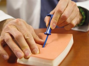 Dr. Peter Guerra demonstrates the insertion technique for a tiny new heart monitor.