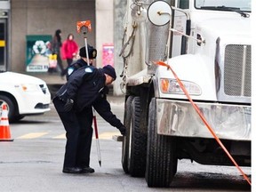 Police inspect the scene where a 16-year-old girl was hit by a recycling truck at Berri St. and Crémazie Blvd. in January 2012. Always assume a truck driver can’t see you unless you make eye contact directly or through the mirrors, Charles Abramovici advises.