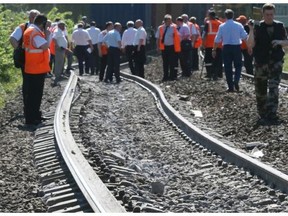 Railway workers examine the railway track at the site of a train collision some 80 km west of Moscow, near the town of Naro-Fominsk, Moscow region, Russia, 20 May 2014. At least four people were killed and 15 injured in the train accident near Moscow, the Russian Interior Minitry reported. According to local media, 16 cars of a freight train derailed, striking a passing passenger train.
