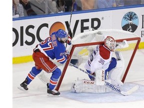Rangers’ Benoit Pouliot, left, pushes the net onto Canadiens goalie Dustin Tokarski during the second period of Game 4 of the Eastern Conference final on Sunday in New York. “Losing sucks, but we have to get it out of our system and get ready for another hockey game,” Tokarski said.