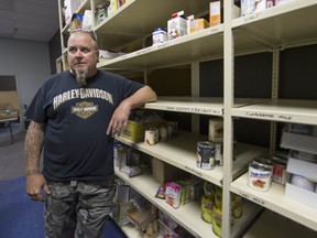 On Rock Community Services founder Kim Reid surveys empty shelves at food bank.