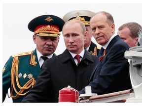 Russian President Vladimir Putin, flanked by Defence Minister Sergei Shoigu, left, and Federal Security Service Chief Alexander Bortnikov, right, arrives on a boat after inspecting battleships during a navy parade marking the Victory Day in Sevastopol, Crimea, Friday, May 9, 2014. Putin extolled the return of Crimea to Russia before tens of thousands Friday during his first trip to Black Sea peninsula since its annexation. The triumphant visit was quickly condemned by Ukraine and NATO.