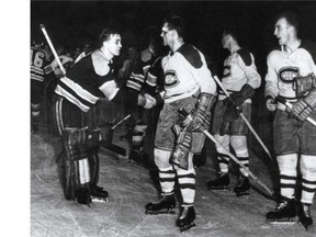 In one of hockey's most compelling photographs, Boston Bruins goalie Sugar Jim Henry (left), his eyes blackened from a broken nose, shakes hands with Canadiens' bloodied Maurice (Rocket) Richard after the Canadiens eliminated the Bruins in Game 7 of the Stanley Cup semi-finals on April 8, 1952. At right is Canadiens defenceman Bud MacPherson. Richard returned from the dressing room late in the game, having been knocked cold in the second period, to score the winner. It is commonly believed to be the greatest goal of the Rocket's career.