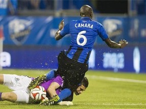 Montreal Impact's Hassoun Camara collides with FC Edmonton's goalkeeper John Smits during second half second leg semi-final Canadian championship soccer action in Montreal, Wednesday, May 14, 2014.