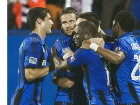 Montreal Impact players celebrate a goal by teammate Patrice Bernier against FC Edmonton during second half of the second leg semifinal Canadian championship soccer action in Montreal, Wednesday, May 14, 2014.