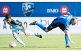 Montreal Impact’s Sanna Nyassi, left, and Sporting Kansas City’s Chance Myers battle for the ball during first half MLS soccer action at Saputo Stadium in Montreal, Saturday, May 10, 2014.