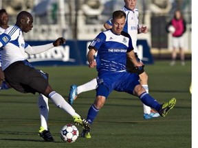 Montreal Impact's Hassoun Camara controls the ball as Edmonton FC's Neil Hlavaty (4) chases during first- half action of the Amway Canadian Championship semi-final in Edmonton, Alta., on Wednesday May 7, 2014.