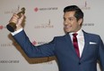 Sugar Sammy holds up his trophy for best comedian of the year at the Gala Olivier awards ceremony Sunday. THE CANADIAN PRESS/Graham Hughes