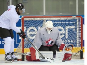 Team Canada goalie Ben Scrivens makes a save on Joel Ward during practice at the IIHF Ice Hockey World Championship in Minsk, Belarus on Wednesday, May 21, 2014. Canada will play Finland in the quarter final match.