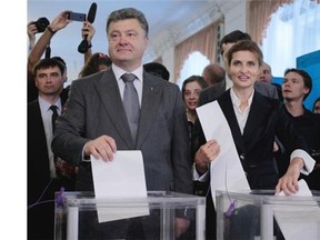 Ukrainian presidential candidate Petro Poroshenko, left,  and his wife Maria, right, cast their ballots at a polling station during the presidential election in Kiev, Ukraine, Sunday, May 25, 2014. Ukraine’s critical presidential election got underway Sunday under the wary scrutiny of a world eager for stability in a country rocked by a deadly uprising in the east.