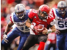 Alouettes’ Chris Wilson, left, and Gabriel Knapton, right, sack Calgary Stampeders quarterback Bo Levi Mitchell during first half CFL football action in Calgary on Saturday.