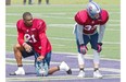 Alouettes linebacker Mike Edem, left, and teammate cornerback Mitchell White take a break during the first day of the team’s training camp, at Bishops University in Sherbrooke.