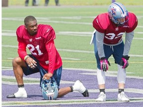 Alouettes linebacker Mike Edem, left, and teammate cornerback Mitchell White take a break during the first day of the team’s training camp, at Bishops University in Sherbrooke.