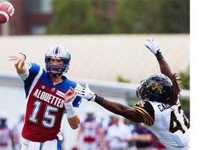 Alouettes quarterback Alex Brink makes a pass despite pressure from Hamilton Tiger-Cats linebacker David Caldwell during pre-season CFL action as the Tiger-Cats take on the Alouettes in Hamilton on Saturday.