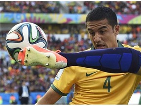 Australia's Tim Cahill, left, watches as Netherlands' Ron Vlaar clears the ball during the group B World Cup soccer match between Australia and the Netherlands at the Estadio Beira-Rio in Porto Alegre, Brazil, Wednesday, June 18, 2014.  (AP Photo/Martin Meissner)