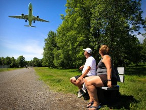George Jones and Johnne Viau watch airplanes land from a bench in Surrey Park in Dorval next to Pierre Elliot Trudeau Airport in Montreal Sunday June 15, 2014.  (John Mahoney  / THE GAZETTE)