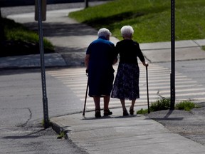 Two elderly women rely on each other for help as they go for a walk in Lac-Mégantic Quebec on Saturday, June 28, 2014. Next weekend is the anniversary of a Montreal, Maine and Atlantic Railway train becoming a runaway train, derailing and exploding in the center of Lac-Megantic on July 6th, 2013 killing 47 people and spilling 5.6 million litres of oil. (Allen McInnis / THE GAZETTE)