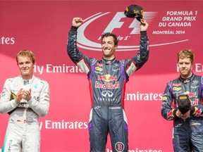 Red Bull F1 driver Daniel Ricciardo of Australia, centre, celebrates his first-place finish in the Canadian Grand Prix along with second-place winner Mercedes F1 driver Nico Rosberg of Germany, left, and third-place winner Red Bull F1 driver Sebastian Vettel of Germany, right, at the Circuit Gilles Villeneuve in Montreal on Sunday, June 8, 2014.