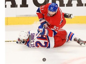 Canadiens’ Max Pacioretty falls over Rangers’ Martin St. Louis while playing the puck during Game 2 of their Eastern Conference final in Montreal.