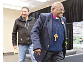 Chief Allan Adam of the Athabasca Chipewyan First Nation, left, and Archbishop Desmond Tutu leave the room together after a press conference in Fort McMurray, Alta. on Friday May 30, 2014.