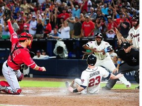 Chris Johnson (23) of the Atlanta Braves is tagged out at home in the 6th inning by Hank Conger (16) of the Los Angeles Angels of Anaheim at Turner Field on June 15, 2014 in Atlanta, Georgia.