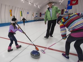 Steve Hewlett instructs young kids on the ice during the Pointe-Claire Curling Club open house Saturday, March 1, 2014.