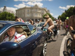 Cyclists ride naked through Madrid, Saturday, June 7, 2014. Cyclists demonstrated against cars and to promote the use of bicycles and to highlight the danger due to lack of cycling lanes in the capital. (AP Photo/Andres Kudacki) ORG XMIT: AK109