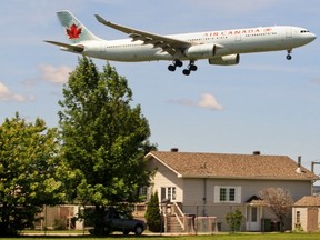 Airplanes fly over houses on Marler Ave. in Dorval on their final approach to Pierre Elliot Trudeau Airport in Montreal Sunday June 15, 2014.