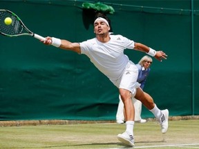 Fabio Fognini of Italy plays a return to Kevin Anderson of South Africa during their men's singles match at the All England Lawn Tennis Championships in Wimbledon, London, Friday, June 27, 2014.