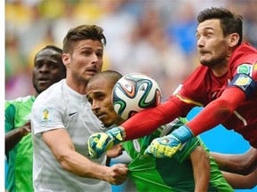 France’s goalkeeper and captain Hugo Lloris (R), France’s forward Olivier Giroud (2L) and Nigeria’s forward Peter Odemwingie (3L) challenge for the ball during the Round of 16 football match between France and Nigeria at The Mane Garrincha National Stadium in Brasilia during the 2014 FIFA World Cup on June 30, 2014.