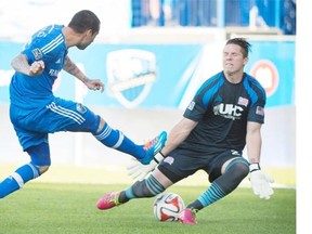 Impact’s Andres Romero, left, scores against New England Revolution’s Bobby Shuttleworth during first half MLS soccer action in Montreal, Saturday, May 31, 2014.