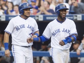 Toronto Blue Jays Melky Cabrera (left) and Jose Reyes celebrate after scoring off a Adam Lind two run double against Chicago White Sox during first inning baseball action in Toronto on Thursday June 26 , 2014. THE CANADIAN PRESS/Chris Young