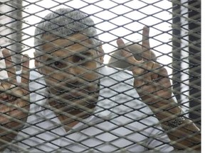 Al-Jazeera news channel’s Egyptian-Canadian Mohamed Fadel Fahmy listens to the verdict inside defendants’ cage during his trial for allegedly supporting the Muslim Brotherhood.