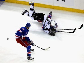 Justin Williams (14) of the Los Angeles Kings and Ryan McDonagh (27) of the New York Rangers collide in front of Rick Nash (61) of the New York Rangers during the first period of Game Four of the 2014 NHL Stanley Cup Final at Madison Square Garden on June 11, 2014 in New York, New York.