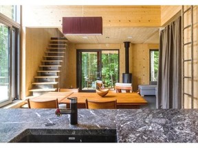 The living room and dining area is seen from the kitchen of this four-season, passive solar family chalet in St-Calixte.