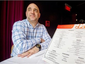 Massimo Lecas, co-owner of Buonanotte restaurant, poses for a photograph with a menu at the restaurant in Montreal, Wednesday, February 20, 2013.