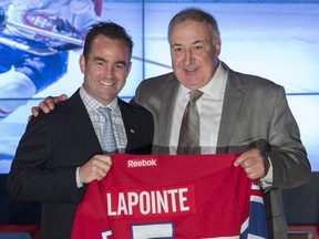 Former Montreal Canadiens' player Guy Lapointe, right, smiles as he poses with club owner and president Geoff Molson at the Canadiens' Hall of Fame in Montreal, Thursday, June 19, 2014. The team is retiring , following a news conference announcing the retirement of his number 5 jersey. THE CANADIAN PRESS/Graham Hughes