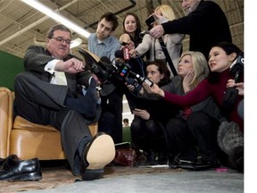 Former Finance Minister Jim Flaherty puts on his annual pre-budget shoes at the Roots Leather Factory in Toronto on Wednesday, March 20, 2013. Flaherty has sometimes warned Canadians there's no free lunch, but on budget day he would be paying for hundreds of them.