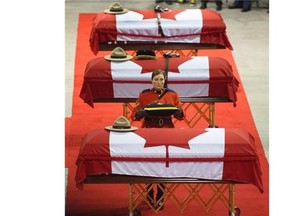 The caskets of the three RCMP officers who were killed in the line of duty are seen at their regimental funeral at the Moncton Coliseum in Moncton, N.B. on Tuesday, June 10, 2014. Const. David Ross, Const. Fabrice Georges Gevaudan and Const. Douglas James Larche were killed in a shooting spree last Wednesday.