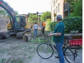 Dimitri Koutsoufis, right, who lives in the neighbourhood watches, as Parc Oxygène is bulldozed on Thursday.